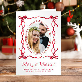 Foto de Navidad de recién casados con arco rojo al