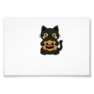 Foto Gato negro lindo sosteniendo la calabaza de Jack O