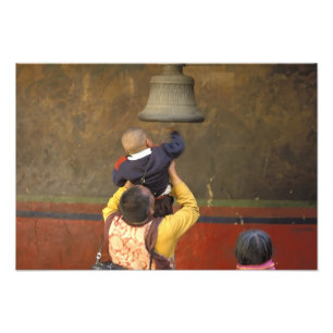 Foto monje budista tibetano levantando a un niño para t