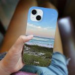 Funda Para iPhone 15 Hermosa fotografía de Sunset Beach personalizada<br><div class="desc">Este pintoresco estuche de teléfono fotográfico de playa incluye una foto de Destin Florida. Personaliza con tu nombre o monograma bajo la magnífica puesta de sol rosa y naranja que toca suavemente las olas del océano sobre la arena y el césped marino. Estuche para iPhone junto al mar para el...</div>