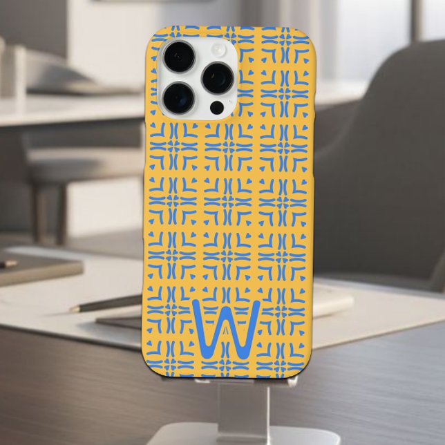 Funda iPhone 16 Pro Max Monograma de Mod Blue Hearts Tiled Mustard (Blue and mustard tiled hearts pattern iPhone case on a cell phone stand on a desk.)