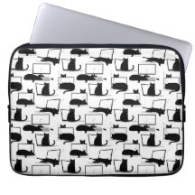 Gatos negros sentados en el patrón de las laptops