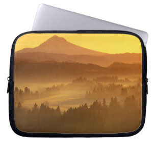 Funda Para Portátil Los colores naranjas del amanecer colorean la nieb