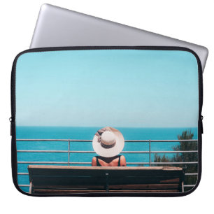 Funda Para Portátil Mujer con gorra de paja blanca sentada en un banco
