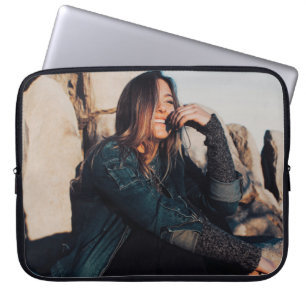 Funda Para Portátil Mujer sentada y sonriente con pantalones negros