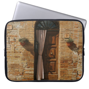 FUNDA PARA PORTÁTIL PUERTA DE MADERA MARRÓN EN UNA PARED DE LADRILLO