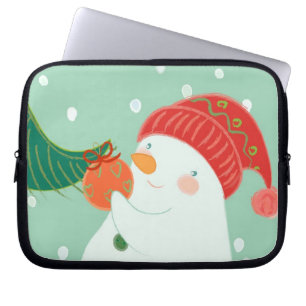 Funda Para Portátil Un muñeco de nieve que cuelga un ornamento en un