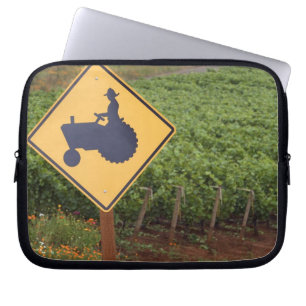Funda Para Portátil Una señal de cruce de tractor amarillo en el viñed