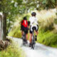 GAFAS DE FIESTA RETRO CYCLING (Two road racing cyclists enjoying the country lanes of Wales. Watercolor.)