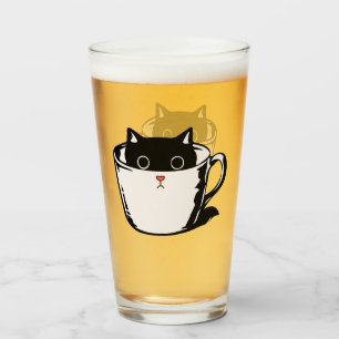 Gatito negro con nariz roja escondido en una taza
