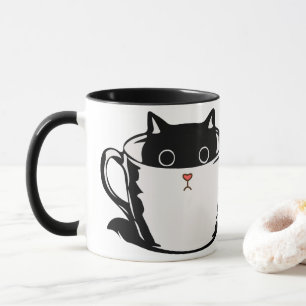 Gatito negro con nariz roja escondido en una taza