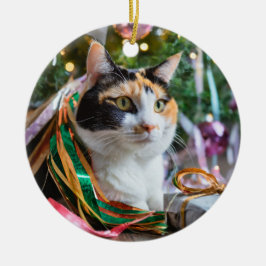 Gato de Calico bajo un adorno de árbol de Navidad