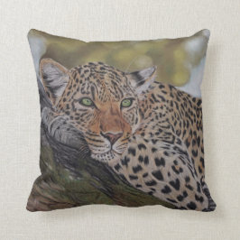 Gato de leopardo que miente en una almohada del
