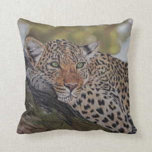 Gato de leopardo que miente en una almohada del