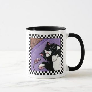 Gato del smoking que duerme cerca de la taza del