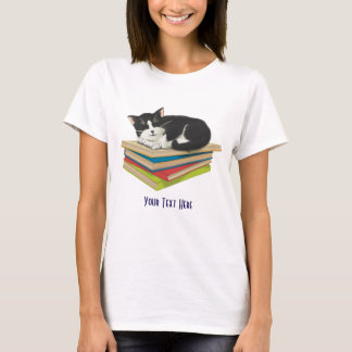 Gato durmiendo en una camisa de libros