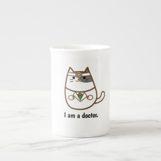 Gato lindo en taza del uniforme del médico