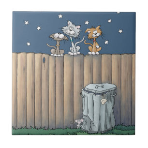 Gatos callejeros en una cerca de baldosas cerámica