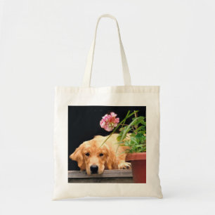 Golden retriever con la bolsa de asas de la flor