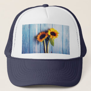 Gorra De Camionero Girasol en la pared de la madera azul