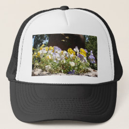 Gorra De Camionero Violetas en un abrevadero de piedra.