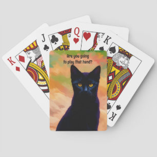 Gracioso gato negro jugando cartas de póker