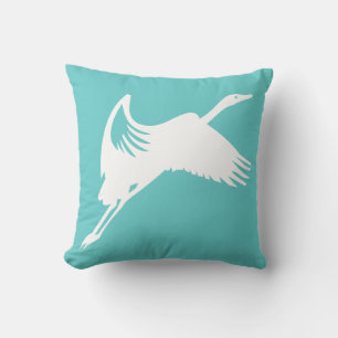 grulla blanca sobre almohada azul turquesa