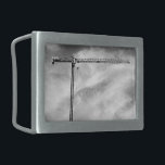 Hebilla De Cinturón Rectangular Grúa de construcción y cielo foto en blanco y negr<br><div class="desc">Lejos de un edificio, una grúa de construcción espera su próxima tarea. La grúa parece una T inclinada, su estrecho brazo negro que se extiende a la derecha de la fotografía. Una delicada pero engañosamente fuerte gama de soportes triangulares forma el interior de la grúa como el puente que construí...</div>
