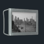 Hebilla De Cinturón Rectangular Línea urbana de Kansas City, foto en blanco y negr<br><div class="desc">En Kansas City, Missouri, la calle principal de seis carriles se extiende desde la esquina inferior derecha de la fotografía en blanco y negro hacia el mítico horizonte de los rascacielos a lo lejos. Un sedán oscuro, bajo y a la izquierda del centro, conduce perpendicular a los carriles del tráfico...</div>