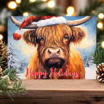 Highland Cow Santa Hat Cuece Navidad<br><div class="desc">Celebra la temporada de fiestas con esta adorable tarjeta de Navidad que incluye una encantadora vaca de la Highland que usa un sombrero de Santa. La escena festiva incluye árboles cubiertos de nieve y un alegre saludo en rojo de "Felices Fiestas". Perfecto para añadir un toque de alegría y calidez...</div>