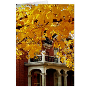 Hojas amarillas de otoño y vieja casa de ladrillo
