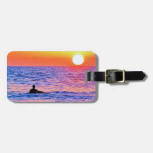 Hombre viendo la etiqueta del equipaje del atardec