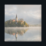 Imán de salida solar del lago Bled Foggy<br><div class="desc">Imán fotográfico de recuerdo de un amanecer nublado en el lago Bled con la isla con iglesia y niebla con reflejo en el agua a la primera luz de la mañana en Eslovenia.</div>