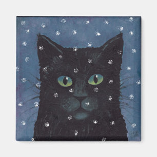 Imán gato negro en nieve del invierno