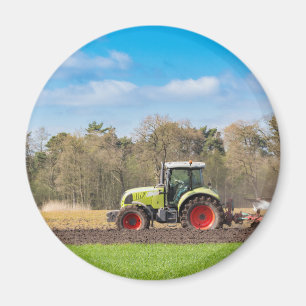 Imán Granjero en el tractor que ara el suelo arenoso en