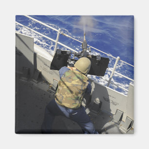 Imán Gunners Mate disparando una ametralladora calibre