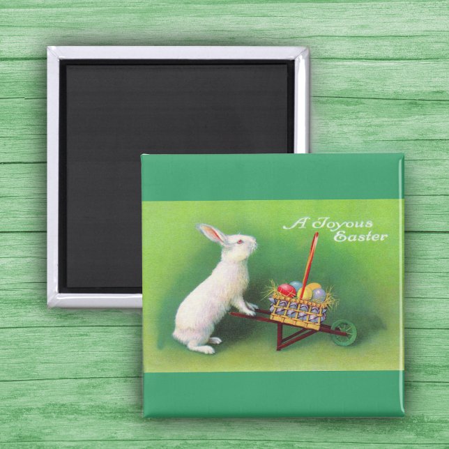 Imán Joyous Easter Bunny y Wheelbarrow Magnet (White Easter Rabbit pushing wheelbarrow with coloured Easter Eggs on green Magnet.)