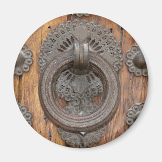 Imán Llamador metalizado en la antigua puerta de madera