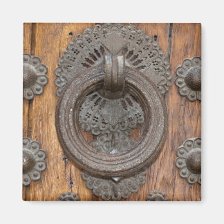 Imán Llamador metalizado en la antigua puerta de madera