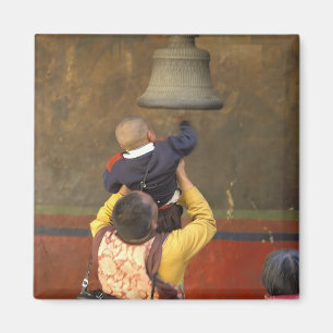 Imán Monje budista tibetano levantando a un niño para q