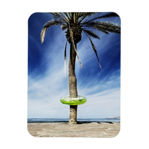 Imán Palmera grande en una playa arenosa con inflable