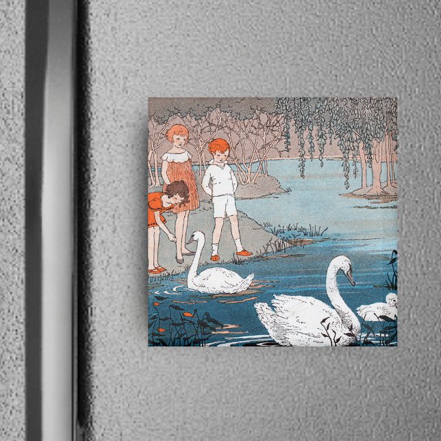 Imán para niños y cisnes (Children red hair at shore of blue lake feeding pretty white swans on square magnet.)