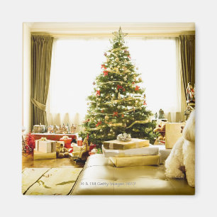 Imán perro posando frente al árbol de Navidad