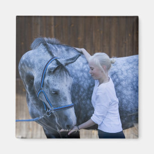 Imán retrato de la chica joven que sostiene el caballo