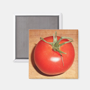 Imán Tomate rojo entero en tablero de madera para corta