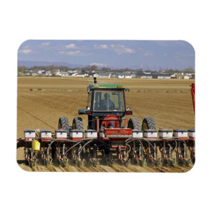 Imán Tractor tirando de un sembrador de maíz.