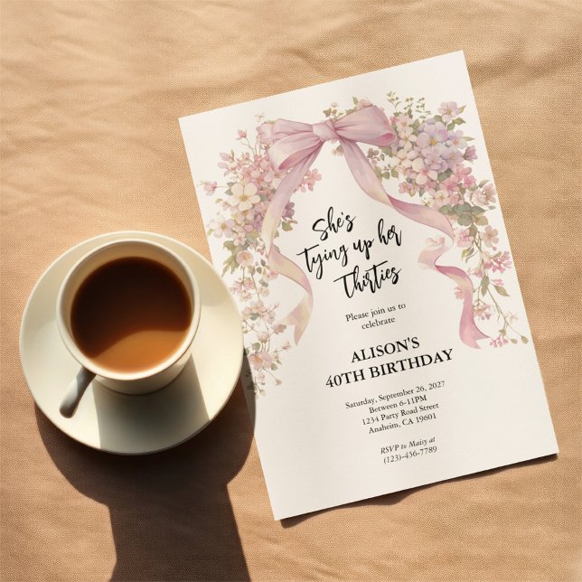 Invitación 40.ª Cinta Floral de Cumpleaños (40th birthday invitation on table top next to a cup and saucer.)