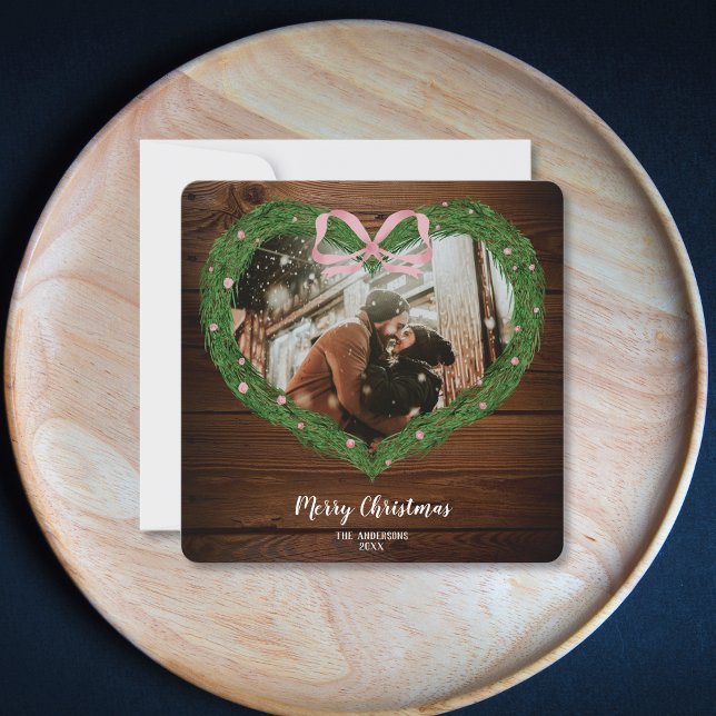 Invitación Granja rústica Feria de Navidad Corazón de flores  (heart shaped christmas wreath with a pink bow on the wood background)