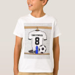 Jersey de fútbol negro personalizado<br><div class="desc">Camiseta de fútbol blanco y negro personalizada, colgada en un vestuario deportivo con una botella de agua, escotillas de fútbol y una pelota de fútbol. Sólo tienes que añadir el nombre y el número (o edad) del jugador de fútbol, hincha de fútbol o entrenador del equipo de fútbol para crear...</div>
