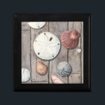 Joyero Tesoros marinos<br><div class="desc">Megan Meagher es conocida por sus simples obras de arte. Esta imagen refleja la sencillez de los tesoros de la orilla del mar, incluidos los dólares de arena y las conchas en un tono pastel. Meagher abarca un fondo de madera en su imagen para contrastar estos tesoros. Obtén esta buena...</div>